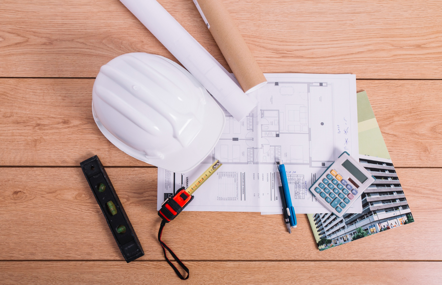 Bureau d’architecte avec plans, outils de chantier et calculatrice pour projet immobilier altier-avocat en gironde